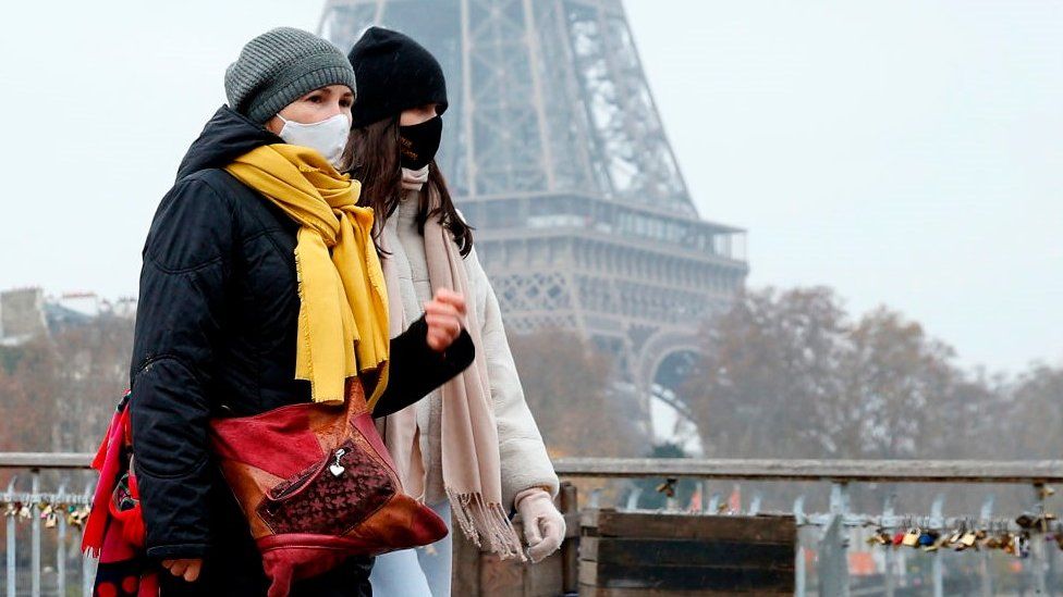 People walk past Eiffel Tower