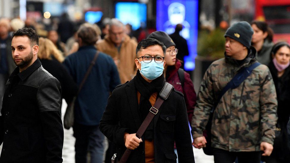 A shopper wearing a protective face mask walks on Oxford Street, as rules on wearing face coverings in some settings in England are relaxed, amid the spread of the coronavirus disease (COVID-19) pandemic, in London