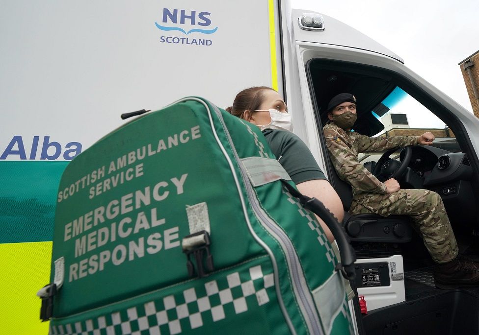 Paramedic with soldier at ambulance