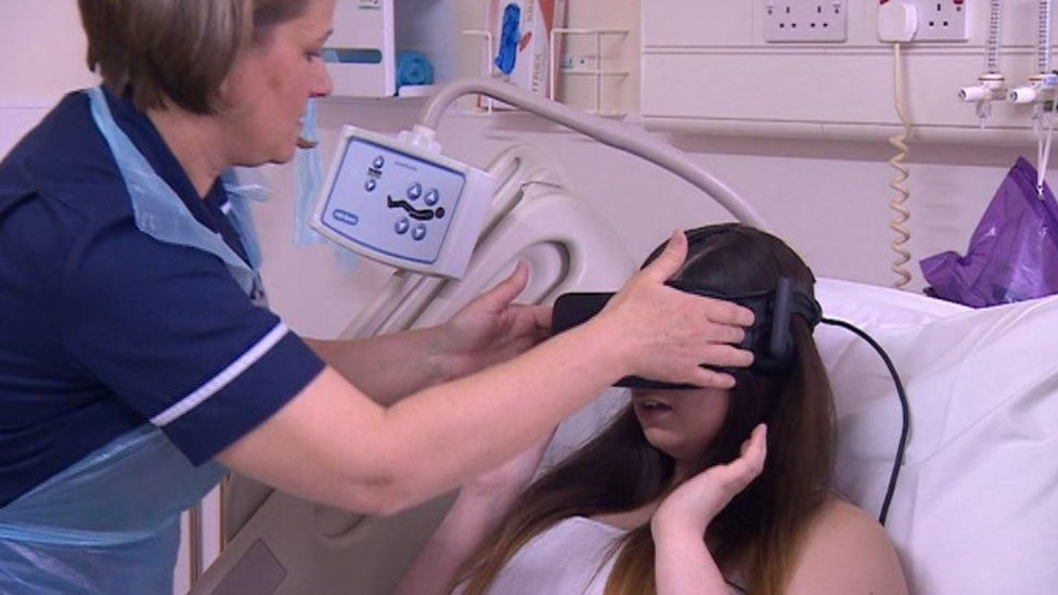 Nurse putting VR headset on patient