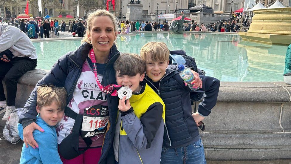 Claire and her sons with her medal
