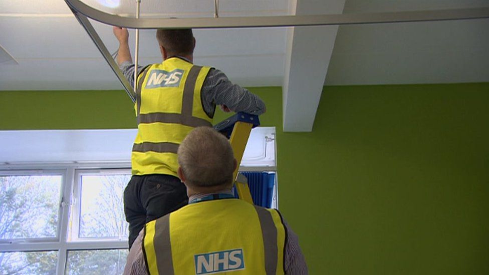 NHS workers looking at a hospital roof