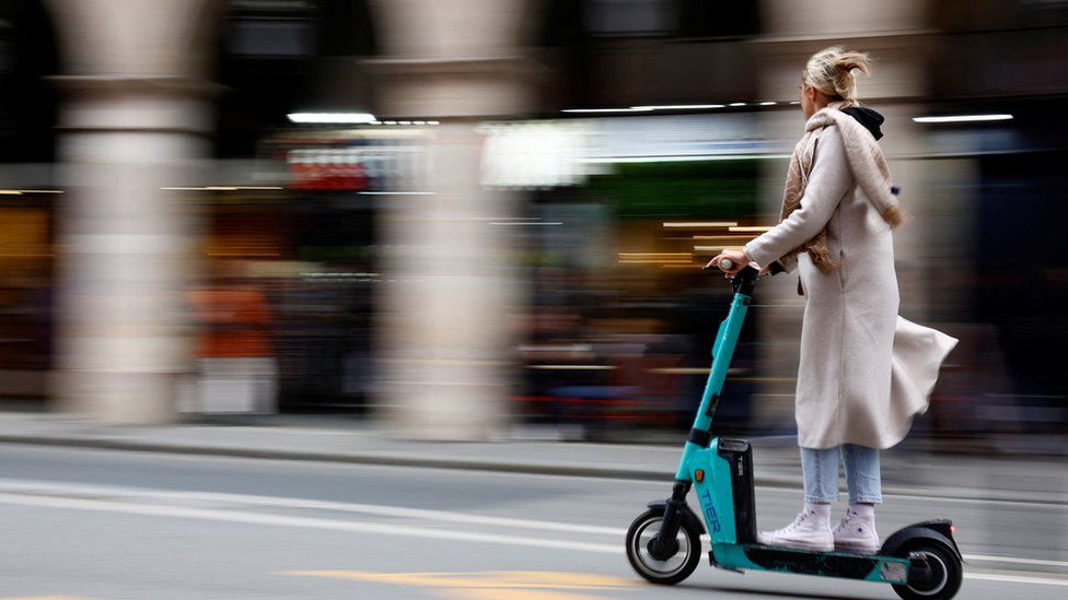 A woman rides an electric scooter in Paris