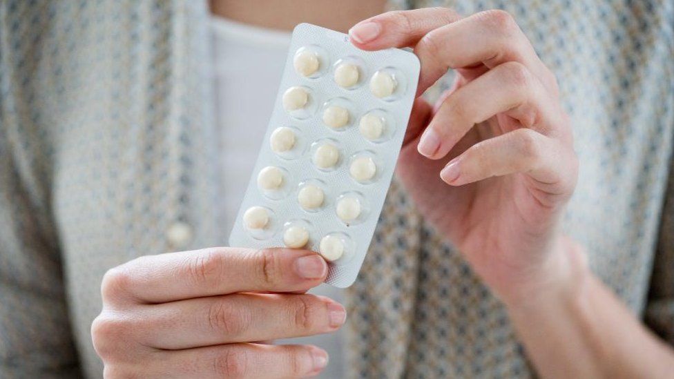 Woman taking an hormone replacement therapy pills (stock image)