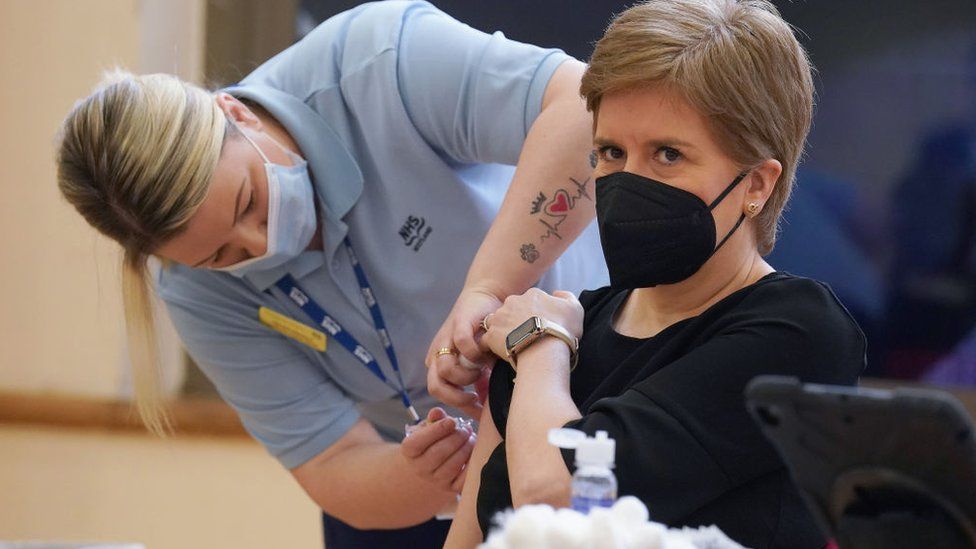 First Minister of Scotland Nicola Sturgeon receives a Covid booster jab and a separate flu jab from healthcare support worker vaccinato